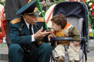 An Armenian war veteran speaks with a young child during Victory Day celebrations in Yerevan (Karen Minasyan/Getty Images).